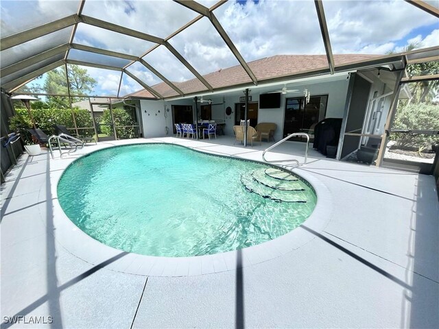 view of swimming pool featuring a lanai, ceiling fan, and a patio area