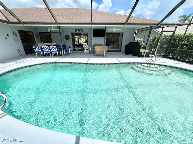 view of pool with a lanai, ceiling fan, and a patio area