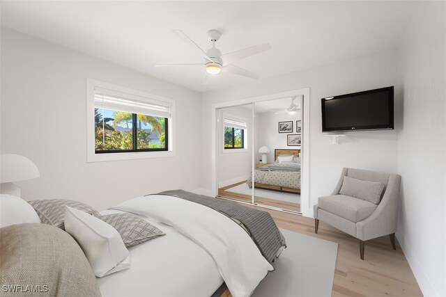 bedroom featuring ceiling fan, light hardwood / wood-style flooring, and a closet