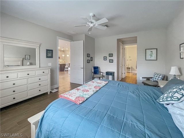 bedroom with ceiling fan, connected bathroom, and dark hardwood / wood-style flooring