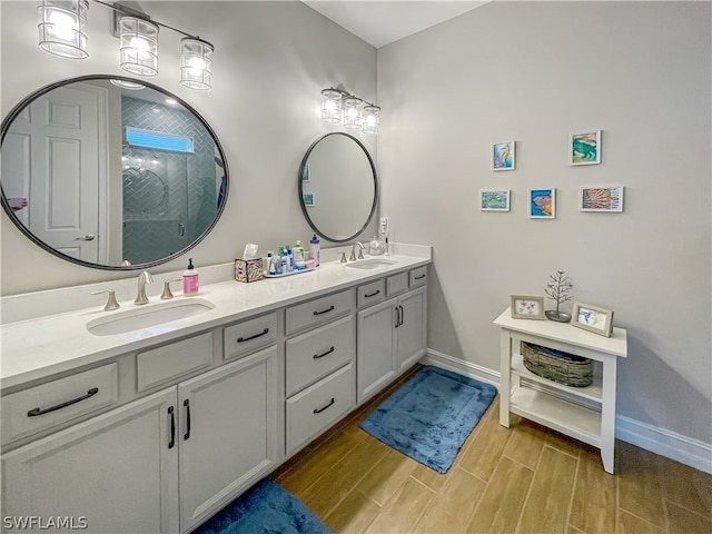 bathroom featuring a shower with door and vanity