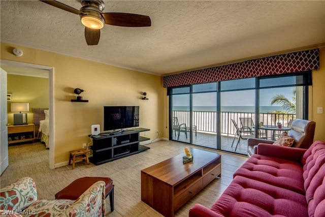 living room with ceiling fan and a textured ceiling