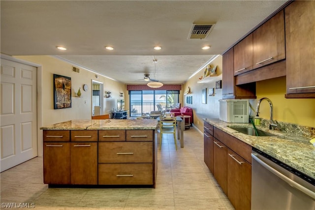 kitchen featuring dishwasher, light stone countertops, ceiling fan, and sink