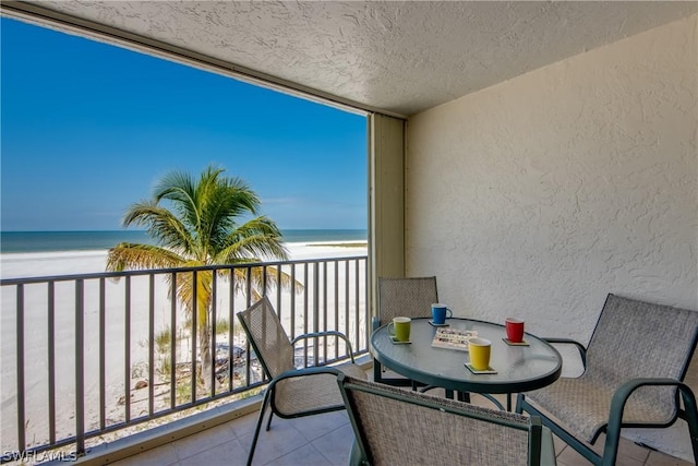 balcony featuring a beach view and a water view