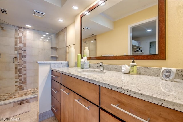 bathroom featuring vanity and a shower with shower door