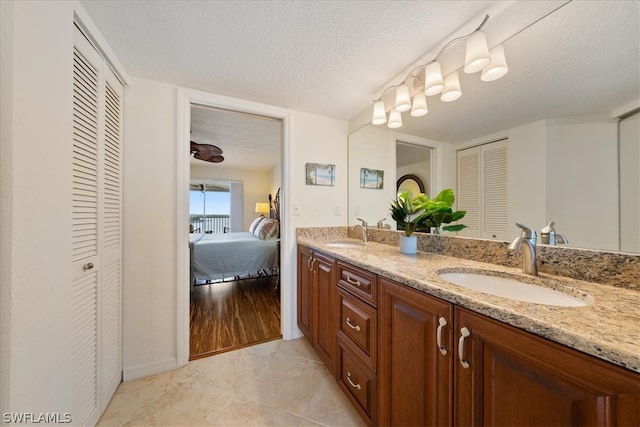 bathroom featuring tile patterned flooring, a textured ceiling, and vanity