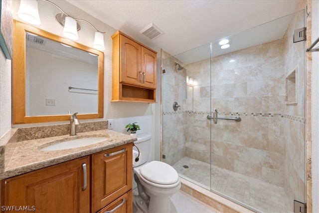 bathroom with an enclosed shower, vanity, and toilet