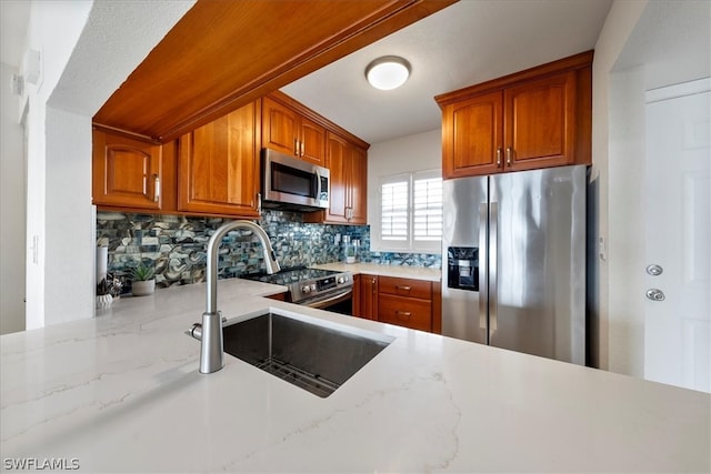 kitchen featuring sink, light stone countertops, stainless steel appliances, and tasteful backsplash