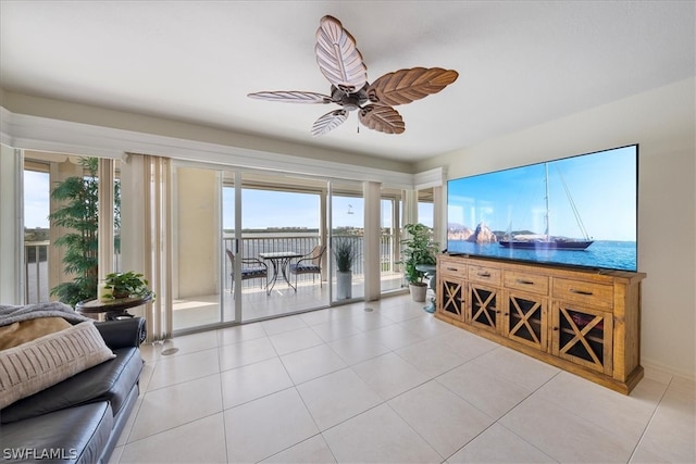 living room with plenty of natural light, ceiling fan, a water view, and light tile patterned flooring