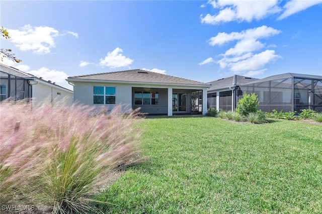 12445 Basalt Ln, Alva, FL 33982 - rear view of house featuring stucco siding, a lawn, and glass enclosure