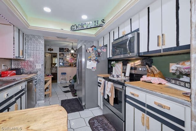 kitchen featuring stainless steel appliances, white cabinetry, and light tile floors