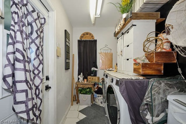 interior space featuring a barn door, washing machine and dryer, and light tile flooring