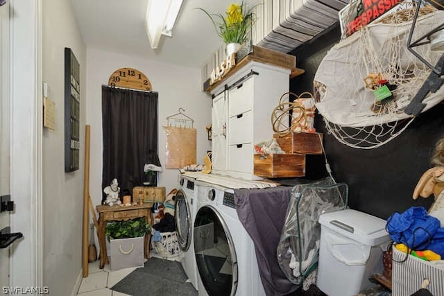 laundry room featuring washer and clothes dryer and light tile floors