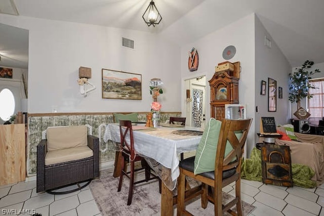 tiled dining room featuring lofted ceiling