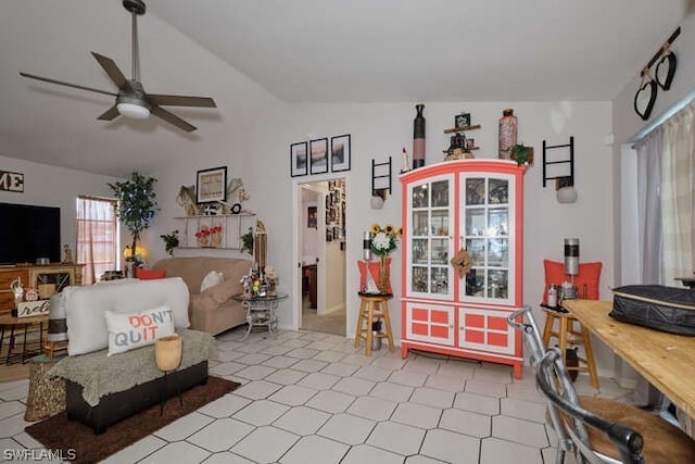 living room featuring lofted ceiling, ceiling fan, and light tile floors