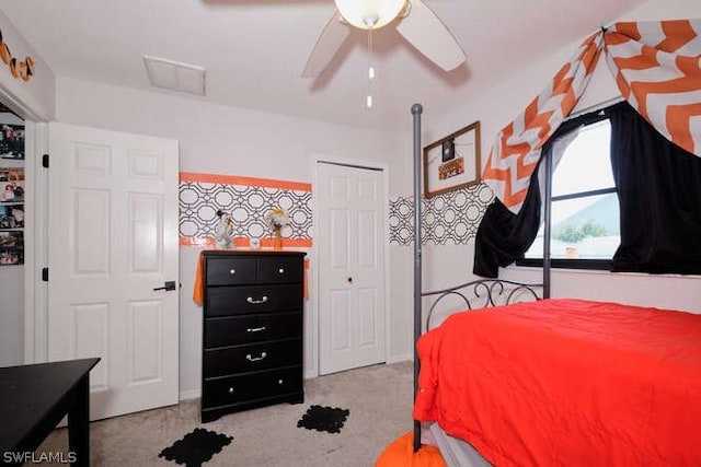 carpeted bedroom featuring a closet and ceiling fan