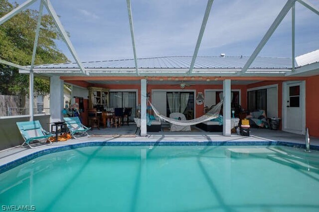 view of swimming pool with glass enclosure and a patio area