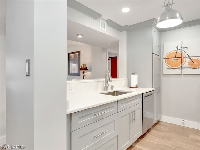 kitchen with dishwasher, sink, light hardwood / wood-style floors, ornamental molding, and decorative light fixtures