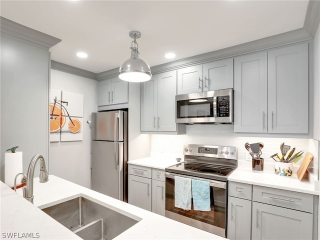 kitchen featuring decorative light fixtures, appliances with stainless steel finishes, tasteful backsplash, gray cabinetry, and sink