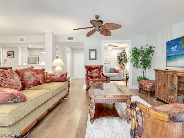 living room featuring ceiling fan and light hardwood / wood-style flooring