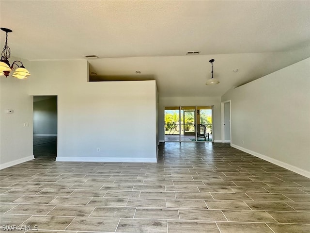 empty room featuring an inviting chandelier, light tile flooring, and a textured ceiling