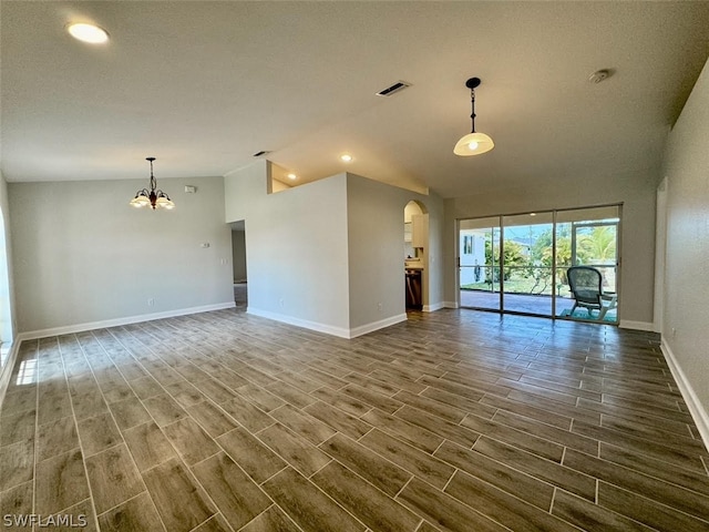 unfurnished living room with high vaulted ceiling, an inviting chandelier, and dark wood-type flooring