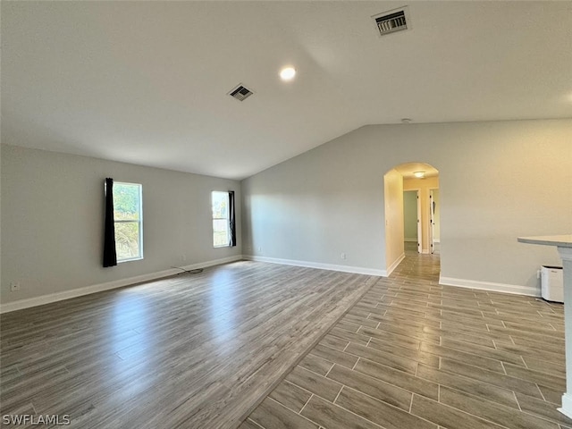 empty room with lofted ceiling and light hardwood / wood-style flooring