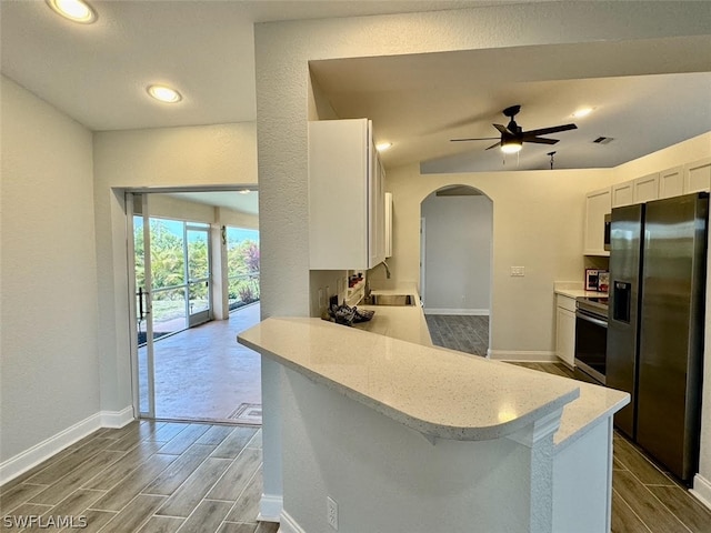 kitchen featuring stainless steel electric stove, fridge with ice dispenser, sink, ceiling fan, and white cabinetry