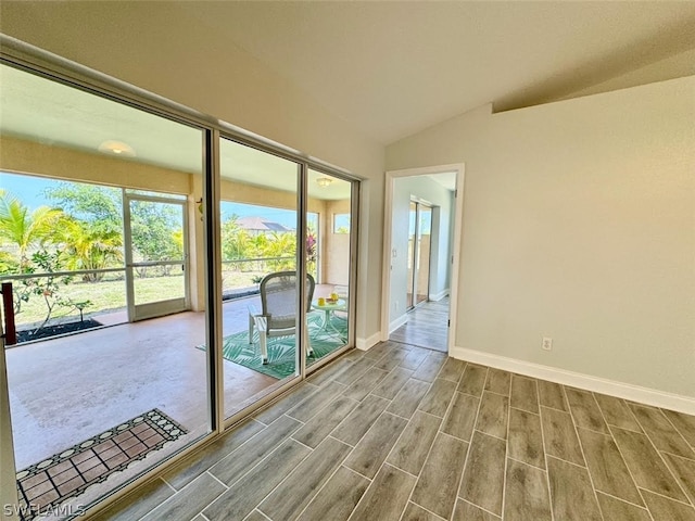 entryway with light wood-type flooring and vaulted ceiling