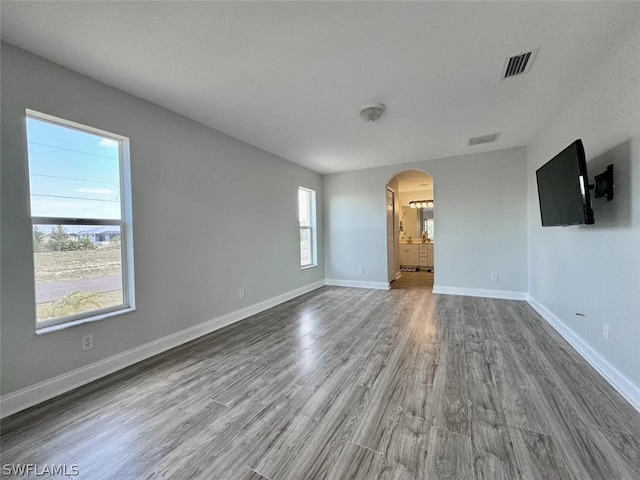 unfurnished living room featuring a wealth of natural light and hardwood / wood-style floors