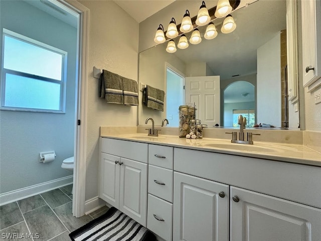 bathroom featuring tile flooring, toilet, dual sinks, and large vanity