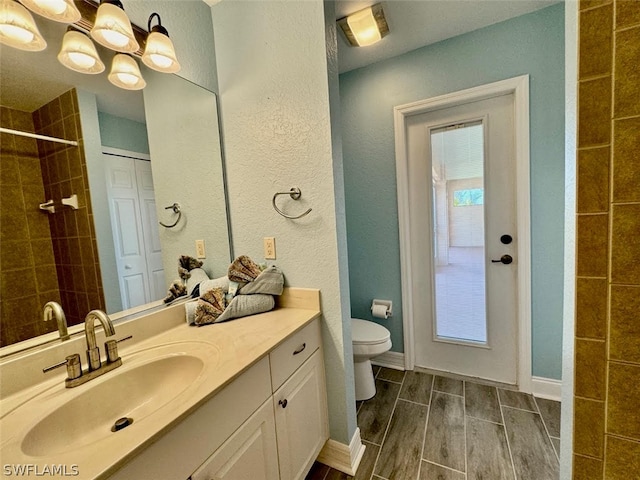 bathroom with toilet and vanity with extensive cabinet space