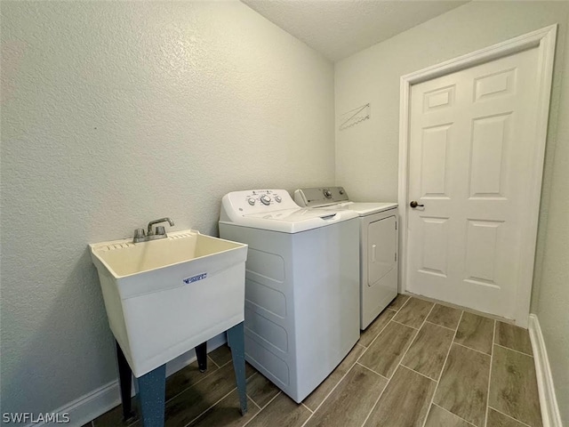 laundry area featuring sink, a textured ceiling, and independent washer and dryer