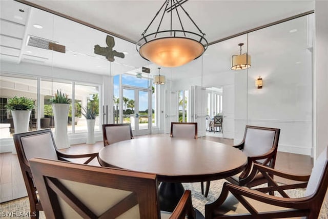 dining space with french doors and wood-type flooring