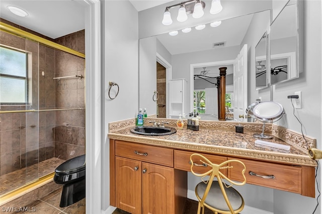 bathroom with plenty of natural light, oversized vanity, a shower with shower door, and tile flooring