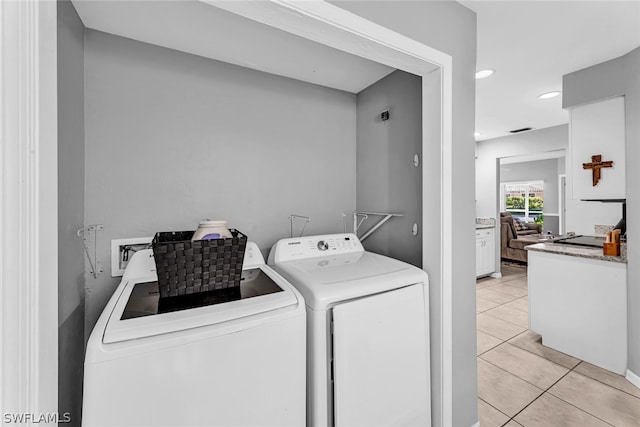 washroom featuring separate washer and dryer, hookup for a washing machine, and light tile floors