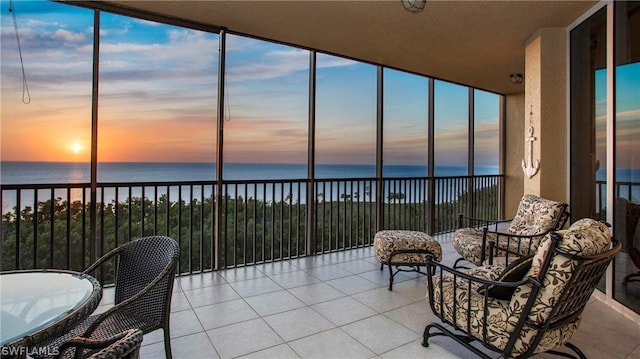 sunroom / solarium featuring a water view