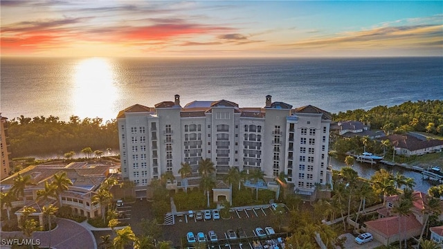 property at dusk with a water view