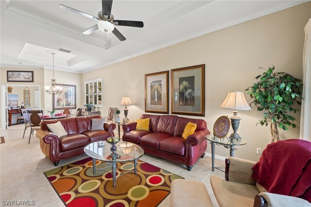 living room with ornamental molding, light tile floors, a tray ceiling, and ceiling fan with notable chandelier