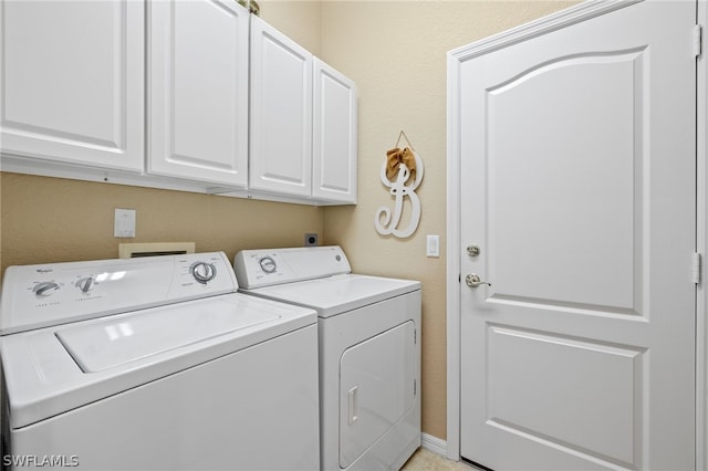 clothes washing area with cabinets and separate washer and dryer