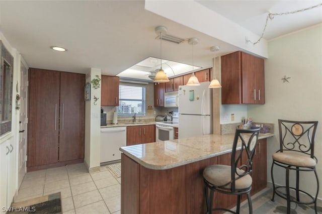 kitchen with a breakfast bar, white appliances, kitchen peninsula, and hanging light fixtures