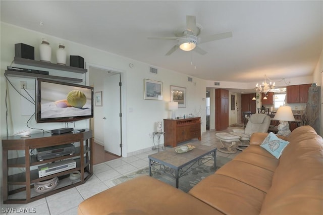 tiled living room featuring ceiling fan with notable chandelier