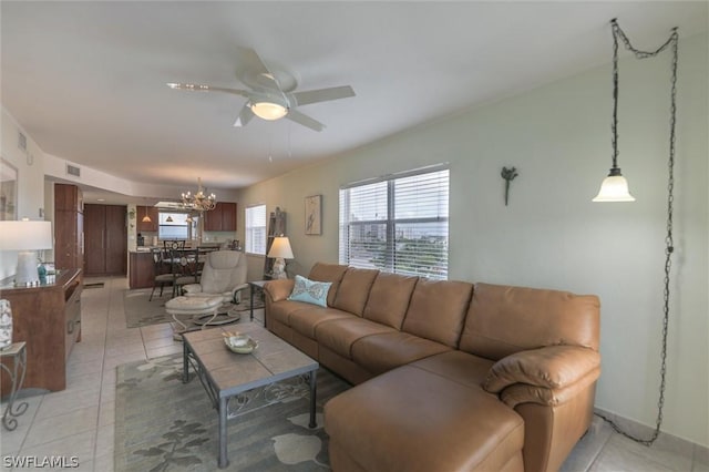 living room with ceiling fan with notable chandelier and light tile patterned floors