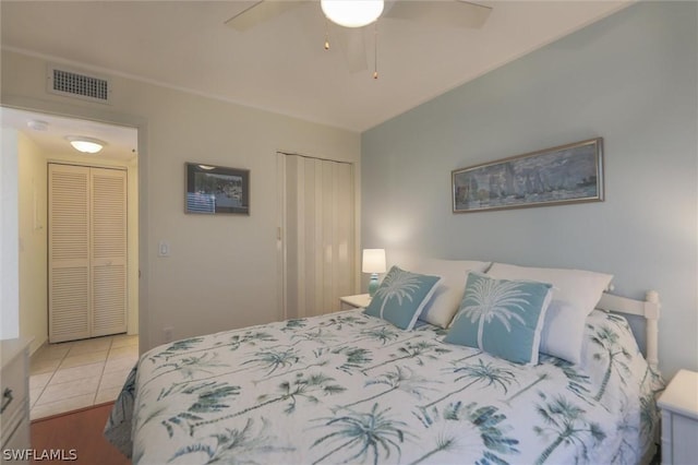 tiled bedroom featuring ceiling fan and a closet