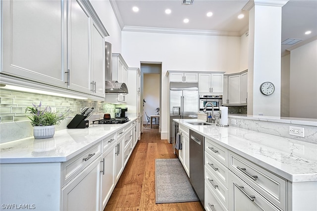 kitchen featuring crown molding, stainless steel appliances, light hardwood / wood-style flooring, light stone countertops, and tasteful backsplash