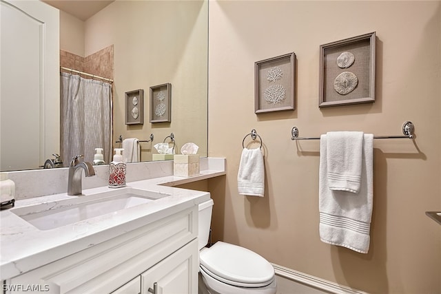 bathroom with toilet and vanity with extensive cabinet space