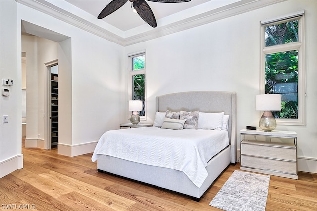 bedroom featuring ceiling fan, crown molding, and light hardwood / wood-style floors