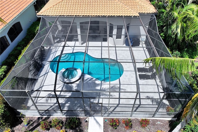 view of pool featuring glass enclosure and a patio area