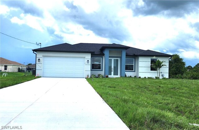 view of front of property with driveway, an attached garage, french doors, a front yard, and stucco siding