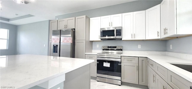 kitchen featuring light stone countertops, appliances with stainless steel finishes, and marble finish floor